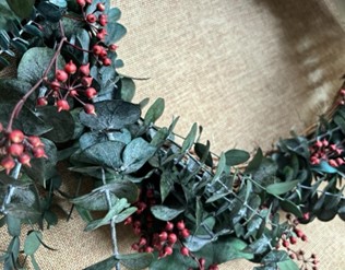 A charming wreath composed of red berries and green leaves, adding a touch of nature to any setting.